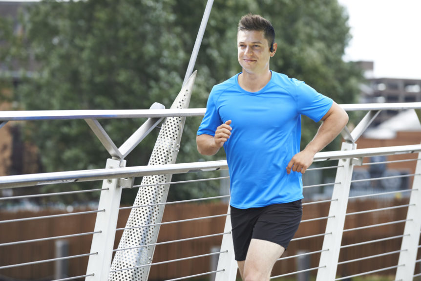 Mann im blauen Laufshirt während seiner Laufeinheit.