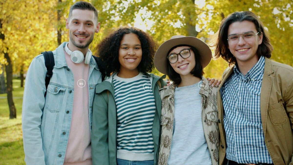 Freundesgruppe mit bedruckten Crewneck-Sweatshirts im herbstlichen Park
